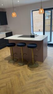 A kitchen island with stools and a cooker.