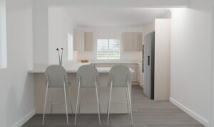 A modern, minimalistic kitchen with three light grey barstools at a white island, white cupboards, a built-in fridge, and two black-stemmed flowers in a vase on the worktop. Sunlight streams through window blinds.