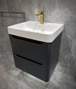Fluted bathroom design under a sink with a gold tap.