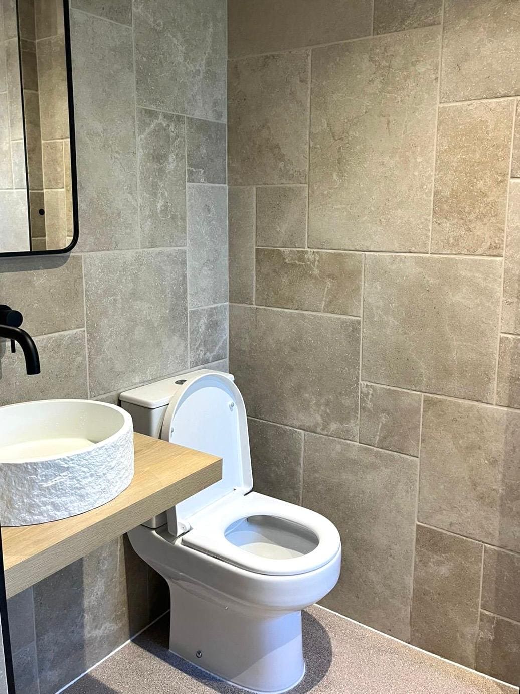 A modern bathroom with beige tiled walls